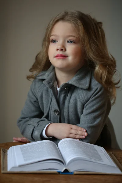 Dziecko dziewczyna z książką. Z bliska. Szare tło — Zdjęcie stockowe