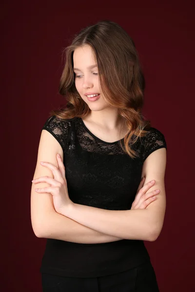 Model with crossed arms. Close up. Dark red background Stock Image