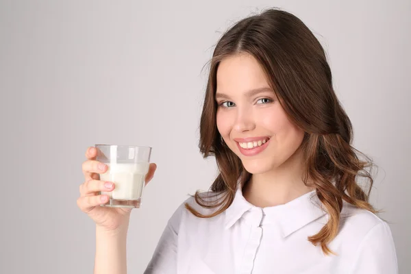 Girl posing with glass of milk. Close up. White background Royalty Free Stock Images