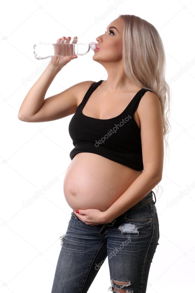 Pregnant girl drinking water. Close up. White background