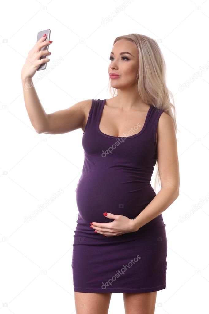 Pregnant woman taking selfie. Close up. White background