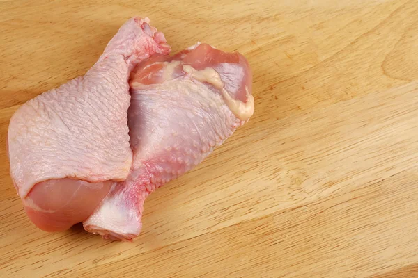 Fresh chicken legs on a cutting board - close up