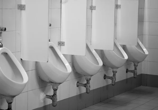 Old white porcelain urinals in public toilets — Stock Photo, Image