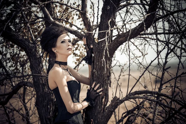 Dark královna v parku. Fantasy černé šaty. — Stock fotografie