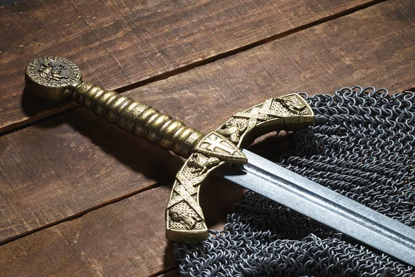 Épée et casque du soldat avec cornes sur un fond en bois — Photo