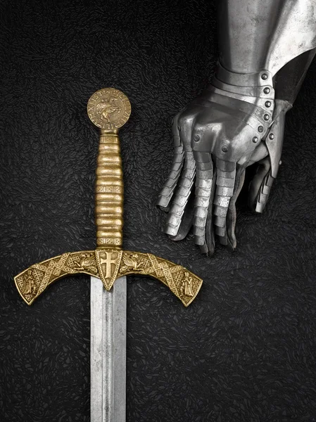 The iron glove of a knight and a sword. — Stock Photo, Image