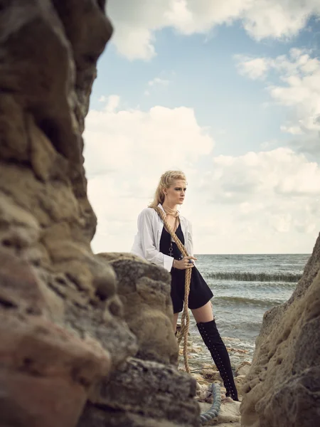 Mooie piraat vrouw stond op het strand in laarzen. — Stockfoto