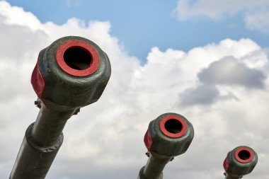 Mavi gökyüzüne doğru ilerleyen bulutlu üç uçaksavarın yakın çekimi..