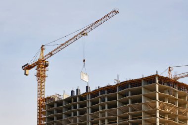 İnşaat halindeki yeni konut kompleksinin önündeki yüksek katlı vinç..