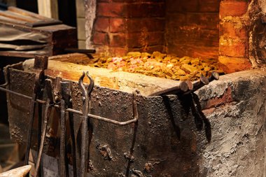 Bir demircinin işyeri. Kazan ve kürkün arka planındaki metal aletler.