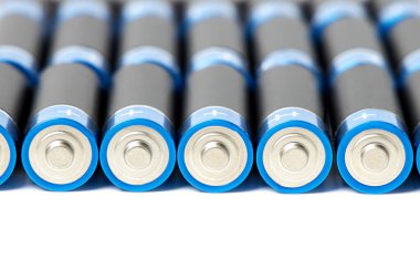 Mavi kenarlı birçok siyah bataryanın yakın çekimi. Beyazda izole edilmiş. Kavramsal resim, metafor.