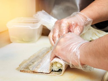 Mutfakta Japon dürümleri hazırlayan bir şefin yakın çekimi.. 