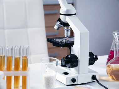 Kimya laboratuvarında mikroskop ve ekipman bulunan bir kimyagerin ya da laboratuvar asistanının iş yerine yakın çekim.