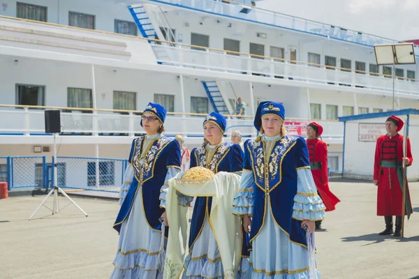 Lányok és asszonyok a nemzeti ruhák találkozott az utasokat a hajó — Stock Fotó
