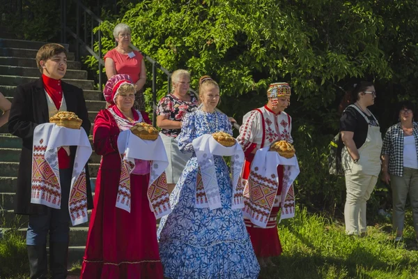 Girls and man in national dresses met passengers from ship — Stock Photo, Image