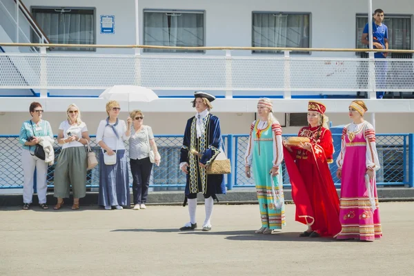女童和妇女的民族服装遇到乘客从船 — 图库照片