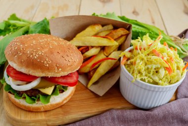 Sandviç ev hamburger yumuşak ekmeği, peynir, domates ve sulu hamburger. Lahana salatası. Patates kızartması. Fast food