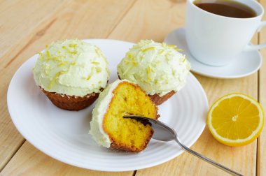 Hafif limonlu kek kek ahşap arka plan ve bir fincan çay