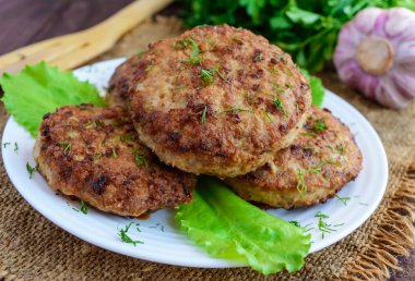 Sulu ev yapımı pirzola (sığır eti, domuz eti, tavuk) ahşap bir arka plan üzerinde. Bir hamburger için
