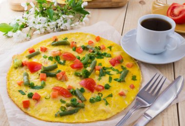 Tahta bir arka plan üzerinde sebzeli omlet ve bir fincan coffe. Kahvaltı