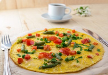 Tahta bir arka plan üzerinde sebze li omlet. Kahvaltı