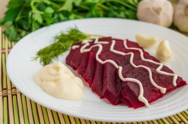 Slices of boiled beets on a white plate with mayonnaise — Stock Photo, Image