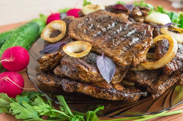 Carne de cerdo, a la parrilla con aros de cebolla y verduras frescas, hierbas — Foto de Stock