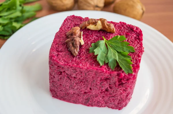 Vitamin salad of boiled beets in the form of a square, with walnuts on a white plate — Stock Photo, Image