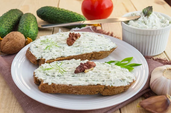 Sandwich nutritif avec pâte de fromage cottage sur pain de seigle sur une assiette blanche — Photo