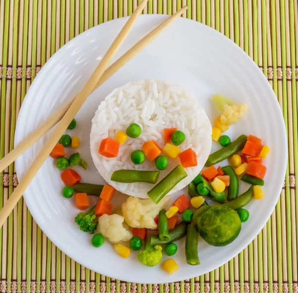 Riz aux légumes cuits à la vapeur sur une assiette blanche, disposée en cercle. Végétalien . — Photo