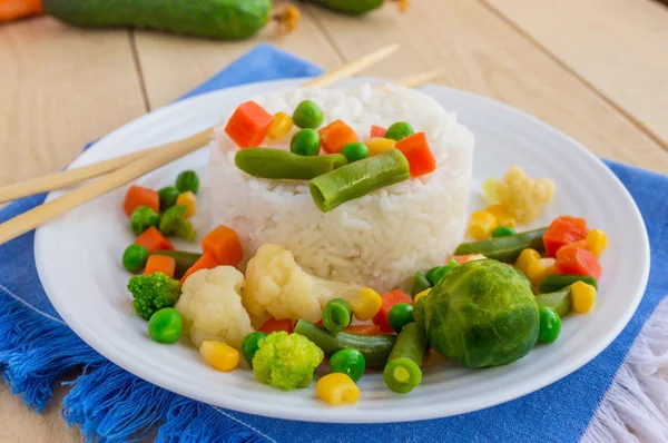 Riz aux légumes cuits à la vapeur sur une assiette blanche, disposée en cercle. Végétalien — Photo
