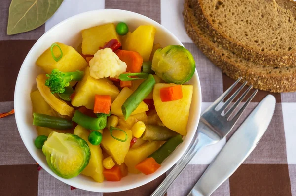 Ragoût de légumes (pommes de terre, asperges, carottes, choux de Bruxelles, maïs, pois, chou de Savoie, brocoli) dans un bol blanc. Végétalien — Photo
