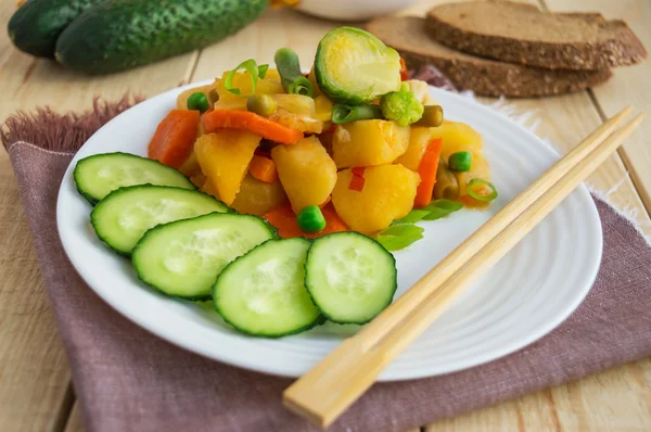 Grönsaksgryta (potatis, sparris, morötter, brysselkål, majs, ärtor, savojkål, broccoli) i en vit platta. Vegan — Stockfoto