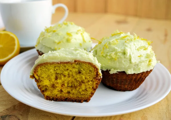 Cupcake al limone leggeri muffin su sfondo di legno e una tazza di tè — Foto Stock