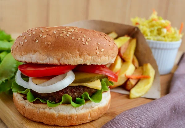 Sandviç ev hamburger yumuşak ekmeği, peynir, domates ve sulu hamburger. Lahana salatası. Patates kızartması. Fast food