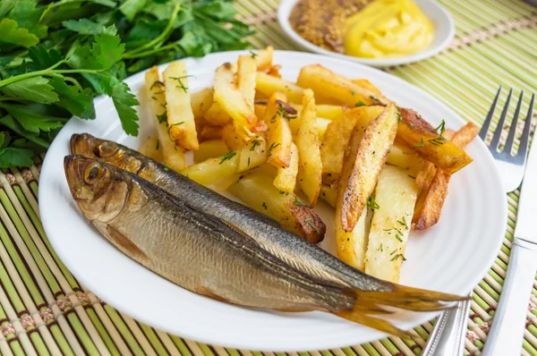 Gebakken aardappelen (frietjes) "at home" met een kleine gerookte vis — Stockfoto