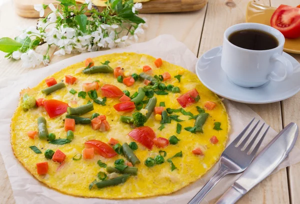 Tahta bir arka plan üzerinde sebzeli omlet ve bir fincan coffe. Kahvaltı