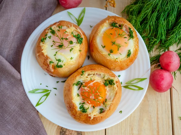 Яйца, запеченные в булочке с ветчиной, сыром и травами. Французский завтрак . — стоковое фото