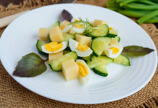 イタリアの春サラダ新鮮なキュウリ、ウズラの卵、モッツァレラチーズ、オリーブ オイルを木製の背景の白いプレートに点灯します。食事食事 — ストック写真