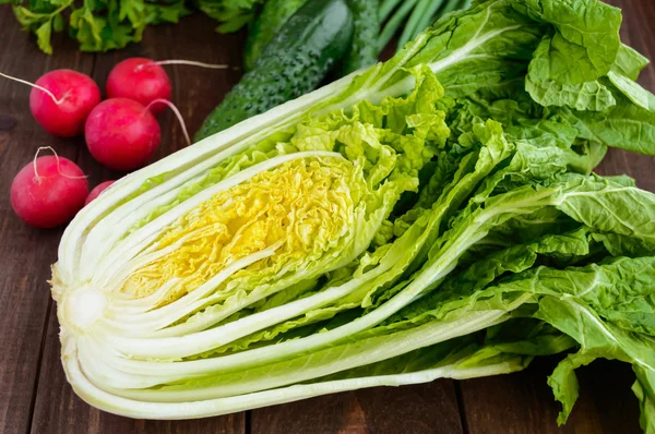 新鲜的绿色蔬菜 （大白菜、 黄瓜）、 绿洋葱、 欧芹和萝卜对木制背景。沙拉. — 图库照片