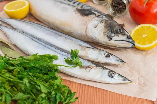 Vis (makreel, saury) en specerijen op houten achtergrond — Stockfoto