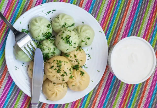 Traditional national Caucasian dish "Khinkali" with sour cream — Stock Photo, Image