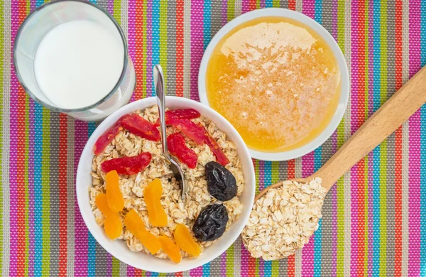 Harina de avena con frutas secas (albaricoques, cornejos, ciruelas pasas), con miel y leche — Foto de Stock