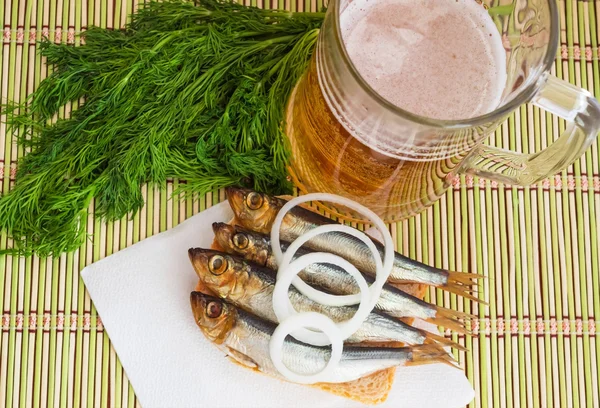 Pequenos peixes fumados (kilka, espadilha, arenque) e cerveja — Fotografia de Stock