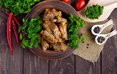 Havuç ile haşlanmış Domuz kaburga maydanoz dekore edilmiş ahşap arka plan üzerinde bir kil kase