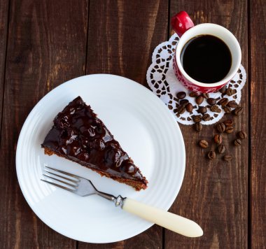 Çikolata ve vişneli pasta. Bir parça üzerinde beyaz tabak yakın çekim. Bir fincan kahve