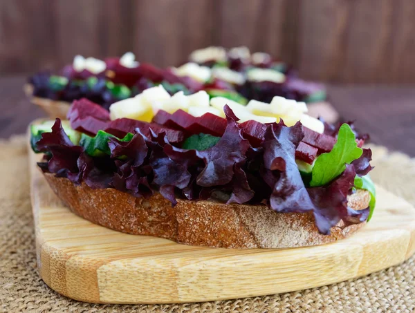 Sanduíches com verduras, tomates, carne, salame em pão crocante na mesa — Fotografia de Stock