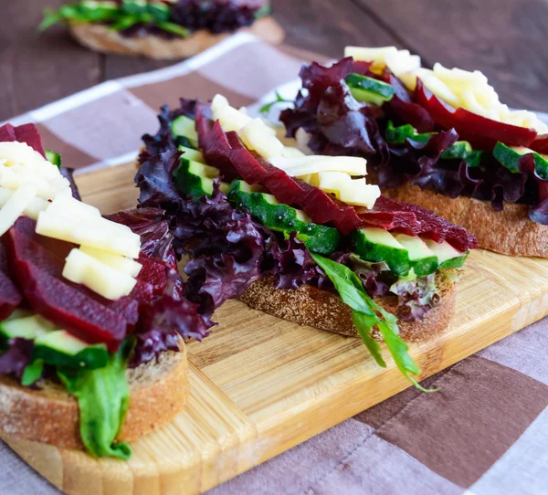 Sanduíches dietéticos de vitaminas com folhas de alface, pepino, beterraba e queijo em pão de centeio — Fotografia de Stock