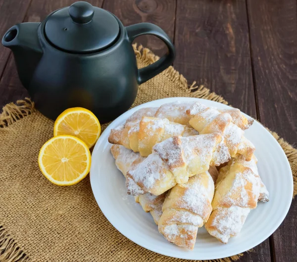 Сладкие домашние лимонные круассаны с сахарной пудрой. Чайник — стоковое фото