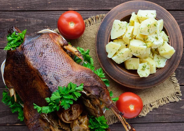 Boiled potatoes in a clay bowl  and roasted goose — Stock Photo, Image